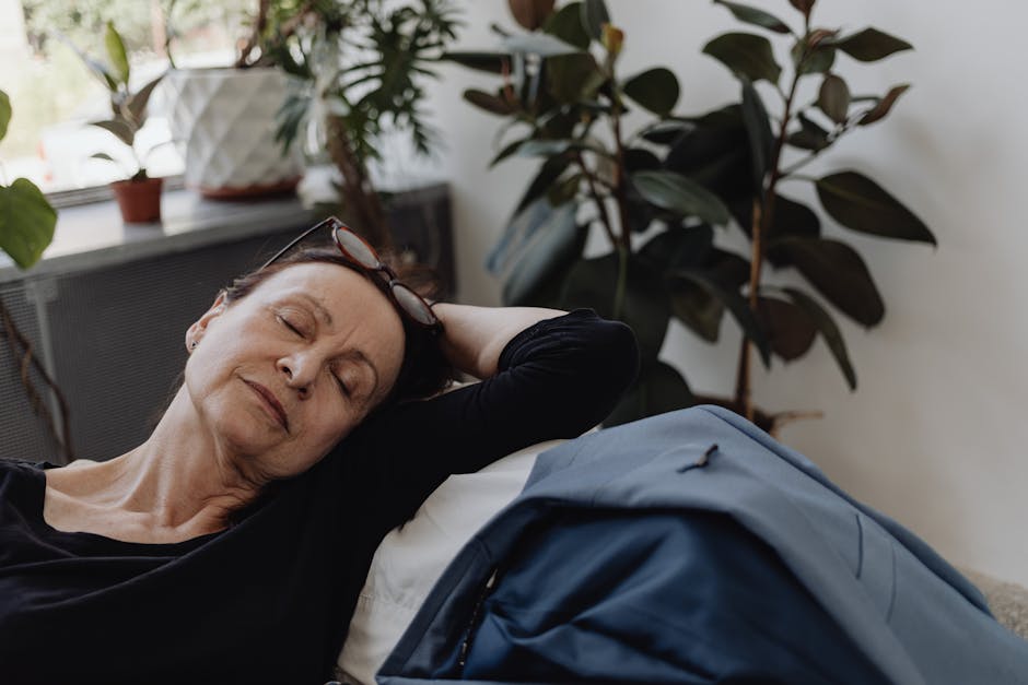 A serene elderly woman relaxing indoors surrounded by houseplants, reflecting peace and calm.