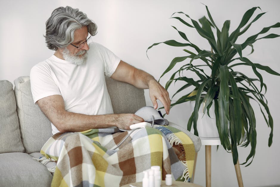 Senior man using a blood pressure monitor while sitting on a sofa, promoting home healthcare and wellness.