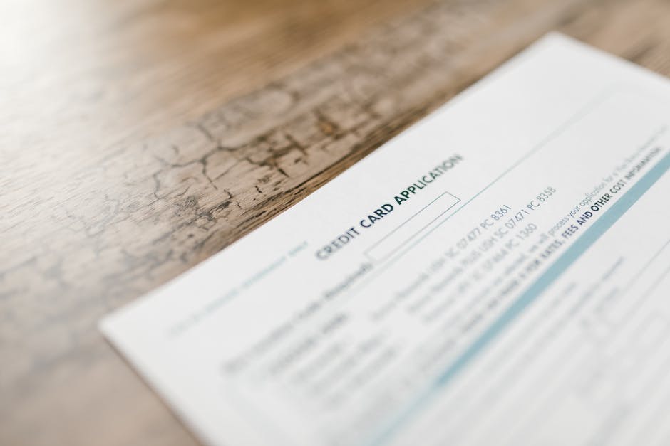 A credit card application on a wooden desk, depicting finance and banking tasks.