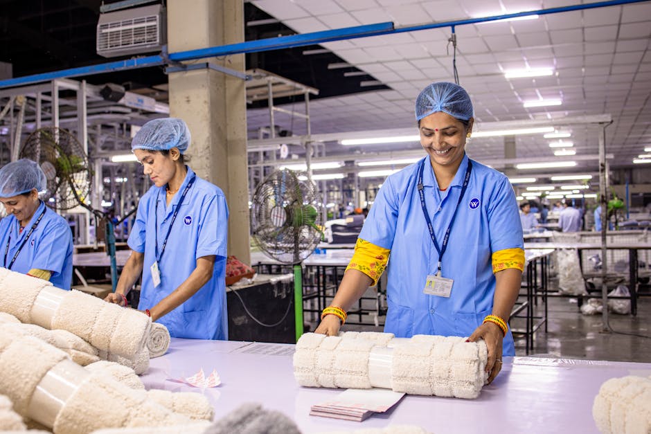 Textile factory workers arranging processed materials with a smile.