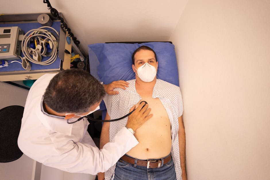 Doctor in protective mask examines patient with stethoscope in medical clinic.