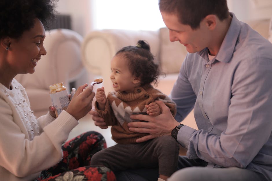 A joyful family bonding over feeding time in a cozy living room setting.