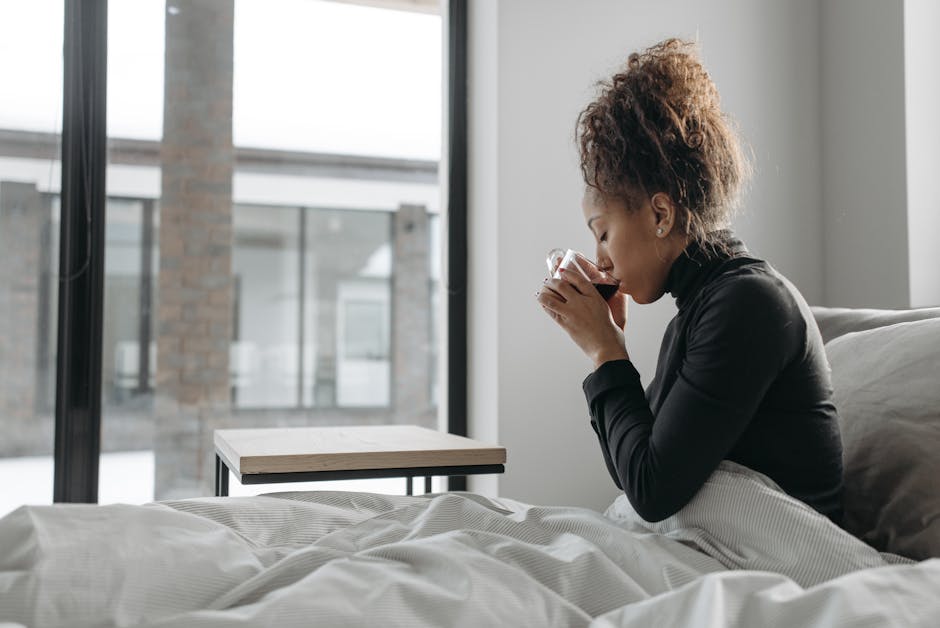 A woman enjoys a warm drink indoors, providing a cozy and relaxed atmosphere.