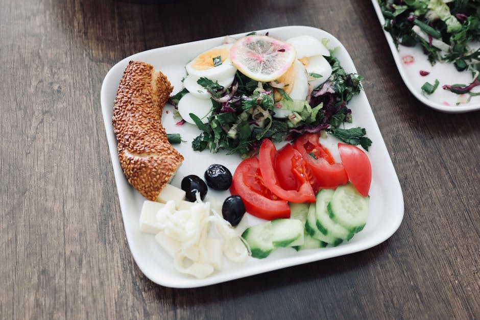 A vibrant Mediterranean breakfast featuring eggs, salad, cucumbers, tomatoes, and more on a plate.