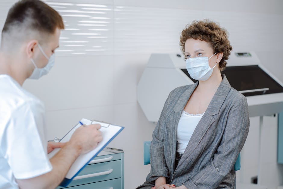 Doctor and patient wearing masks during a medical consultation in a modern healthcare setting.