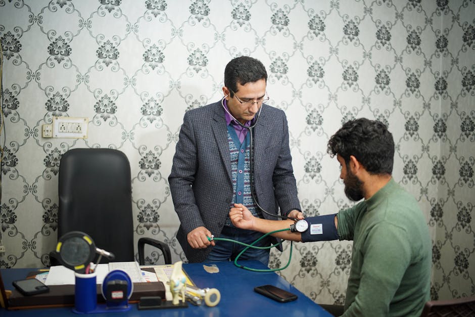 Doctor checking patient's blood pressure during medical consultation indoors.