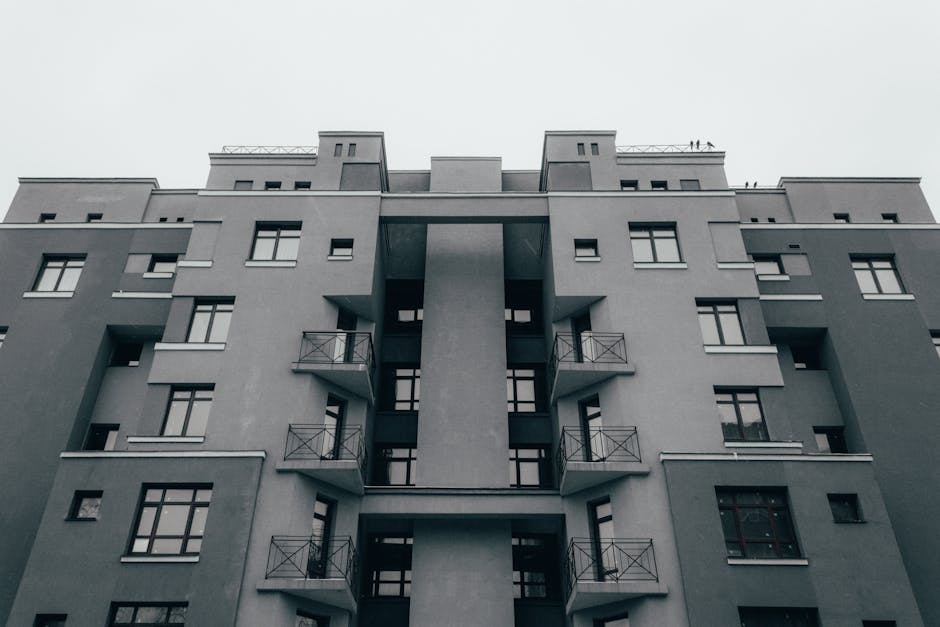 Low-angle view of a minimalist apartment facade, showcasing modern architectural design and symmetry.