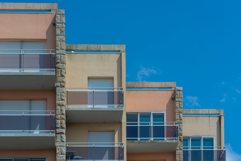 Modern apartment building with balconies against clear blue sky. Urban architecture scene.