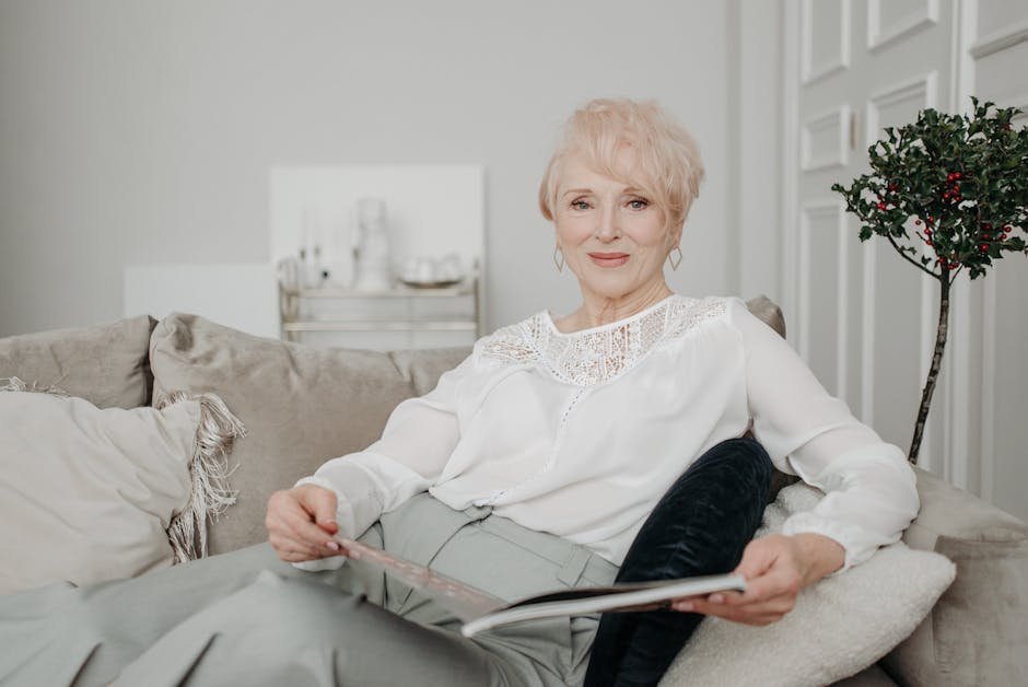 Elderly woman with short hair relaxing on a sofa indoors, exuding grace and warmth.