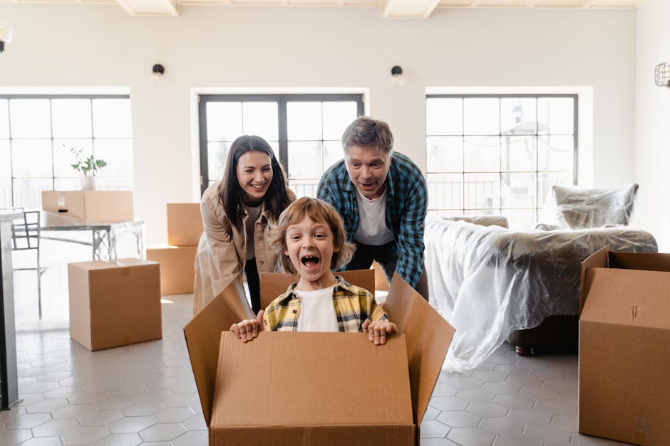 Family playing with cardboard boxes during move into a new home, symbolizing joy and togetherness.