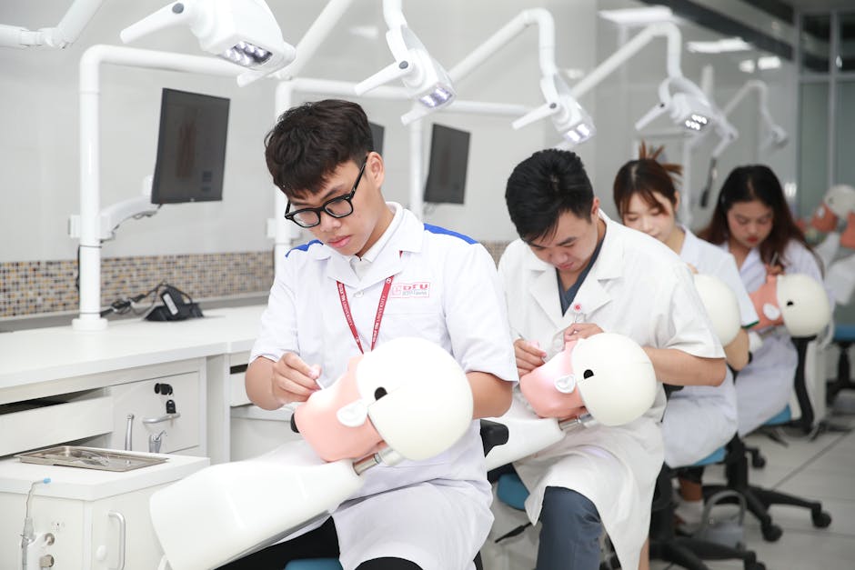 Dental students in a training lab practicing on mannequin heads for skill development.