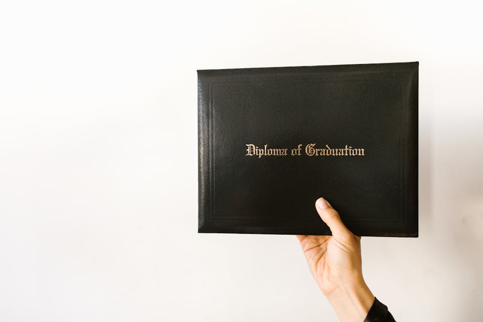 Close-up of a hand holding a graduation diploma with elegant typography.