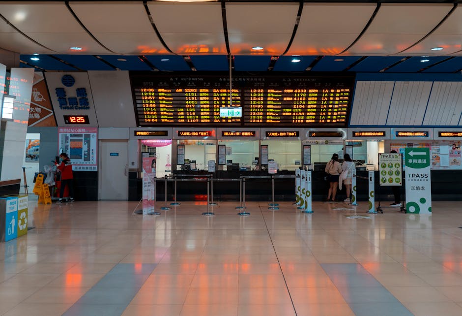 Interior of a train station with a digital timetable and ticket counters.