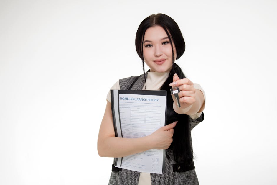 Asian woman smiling while holding a home insurance policy and a key, symbolizing new home ownership.
