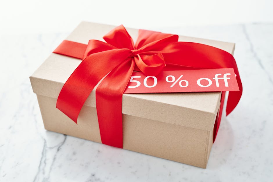 Cardboard gift box with a vibrant red ribbon offering a 50% off discount.