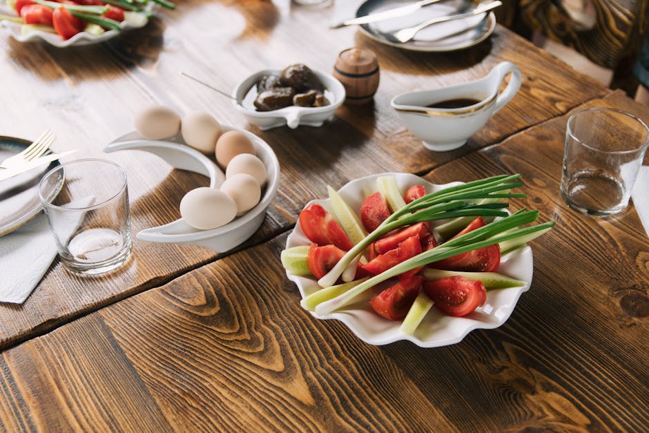 A rustic breakfast setting featuring fresh vegetables, eggs, and condiments on a wooden table.