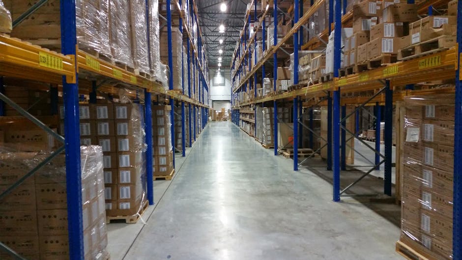 Interior view of a large warehouse aisle lined with stacks of organized cardboard boxes.