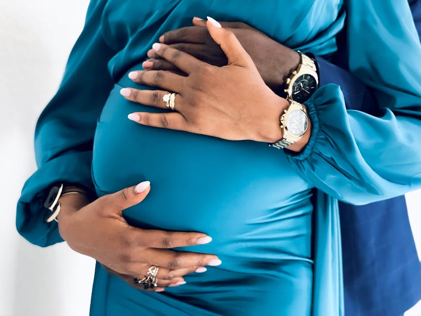 Close-up of a couple's hands on a pregnant belly, emphasizing love and anticipation.