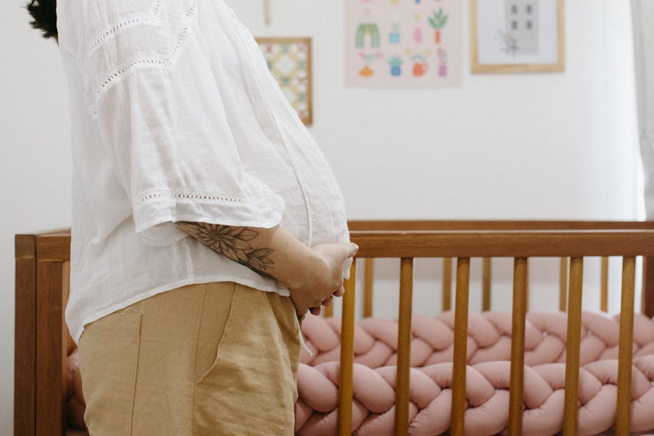 Expecting mother in a nursery holding her belly, symbolizing anticipation and parenthood.