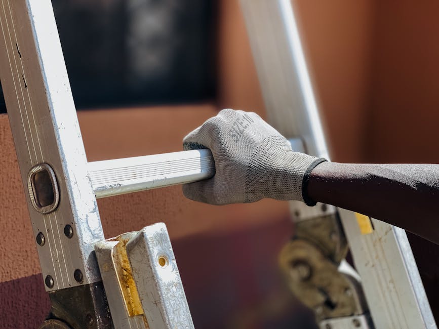 Close-up of a person climbing a ladder with a protective glove outdoors.