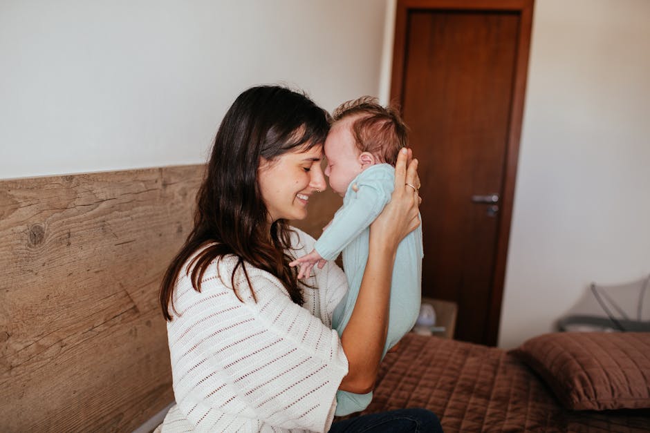 A loving mother embraces her baby in a warm, cozy bedroom setting, highlighting family affection.