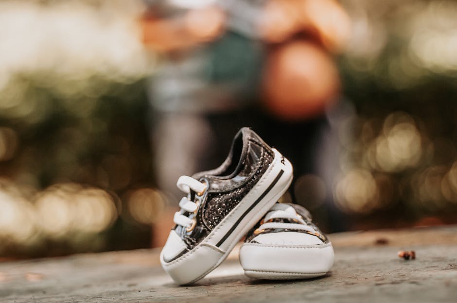 Charming close-up of baby shoes set against a blurred bokeh background, perfect for family or maternity themes.