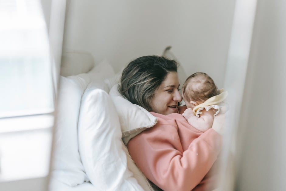 A tender moment shared between mother and baby, showcasing love and togetherness indoors.