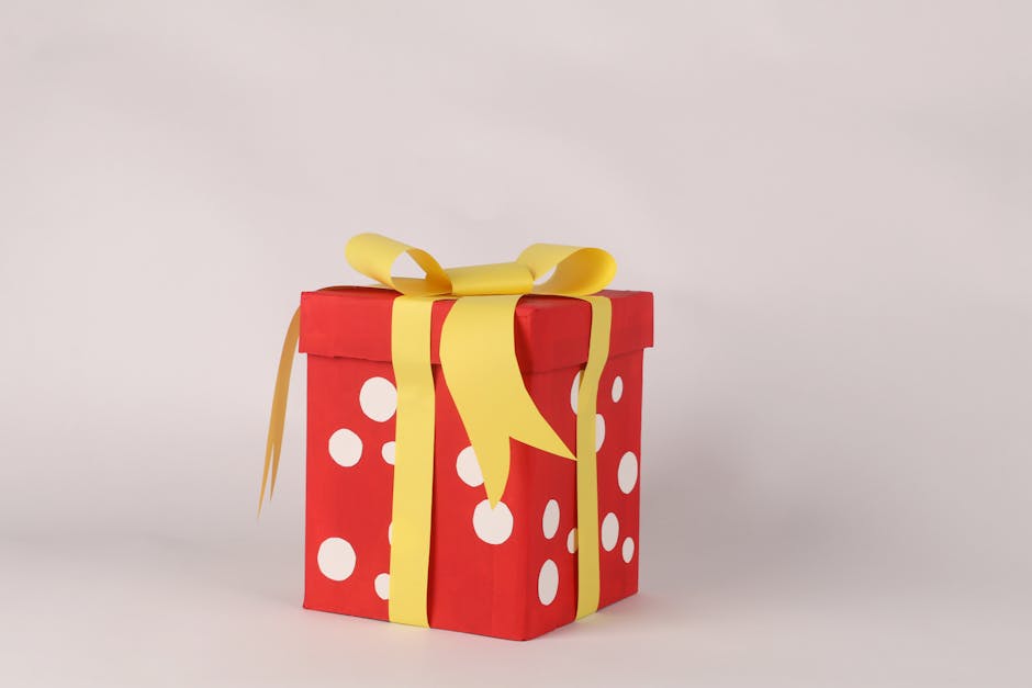 A red gift box with white polka dots and a yellow ribbon, perfect for celebrations.