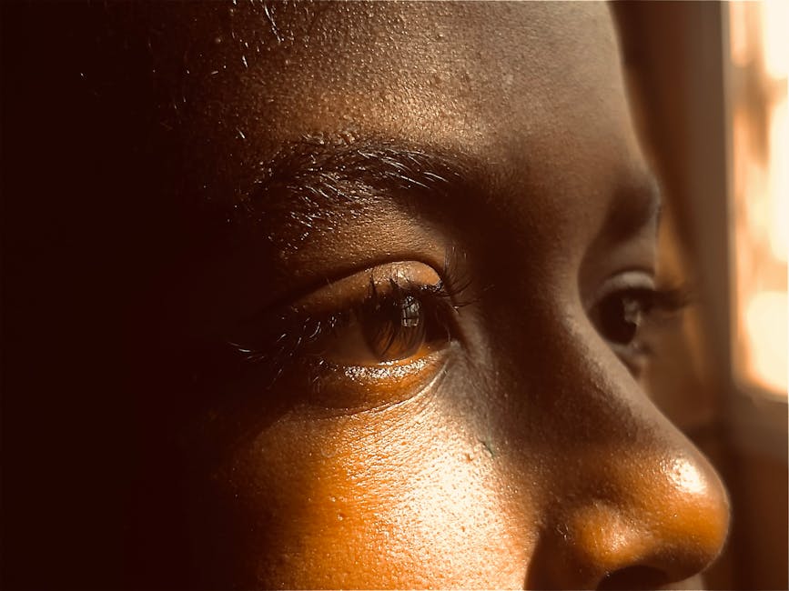 A close-up of a young person's eye, reflecting a warm and serene atmosphere.
