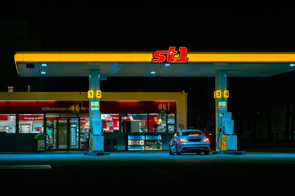 A car refuels at the illuminated St1 gas station in Jönköping, Sweden at night.