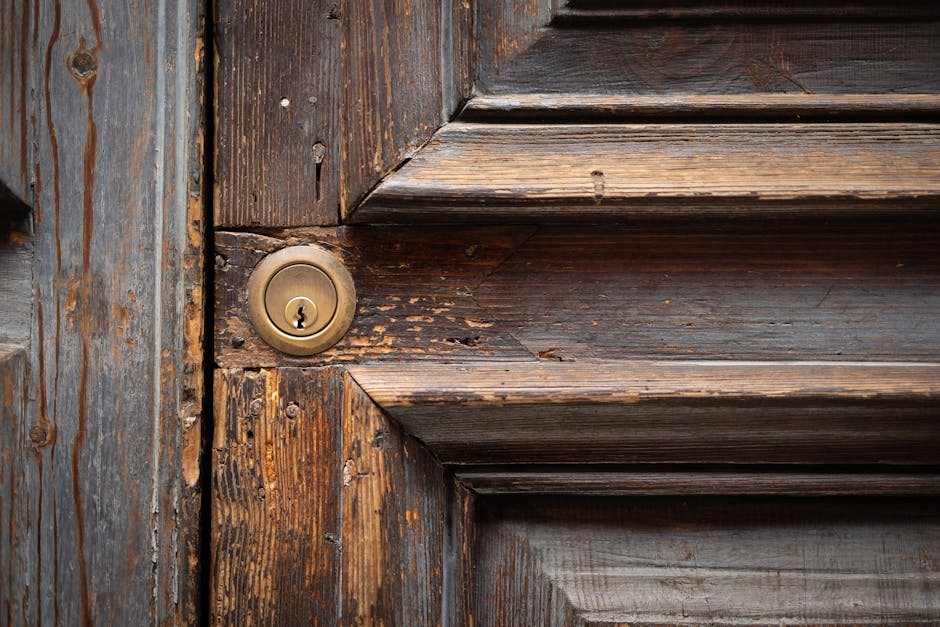 Detailed view of a rustic wooden door with a brass keyhole, highlighting texture and age.