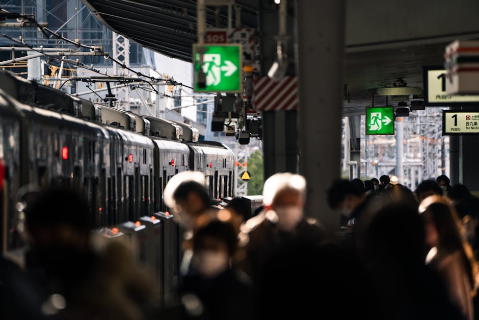 Crowd at Osaka train station platform with train in view, showcasing urban travel hustle.
