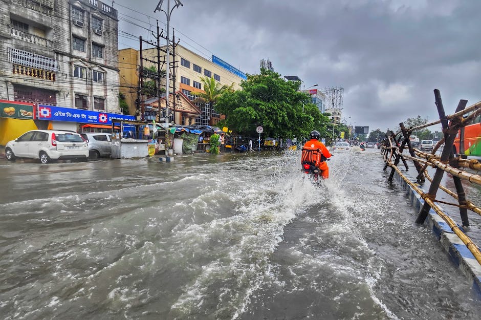 A motorcyclist rides through waterlogged streets in Kolkata during the monsoon season.