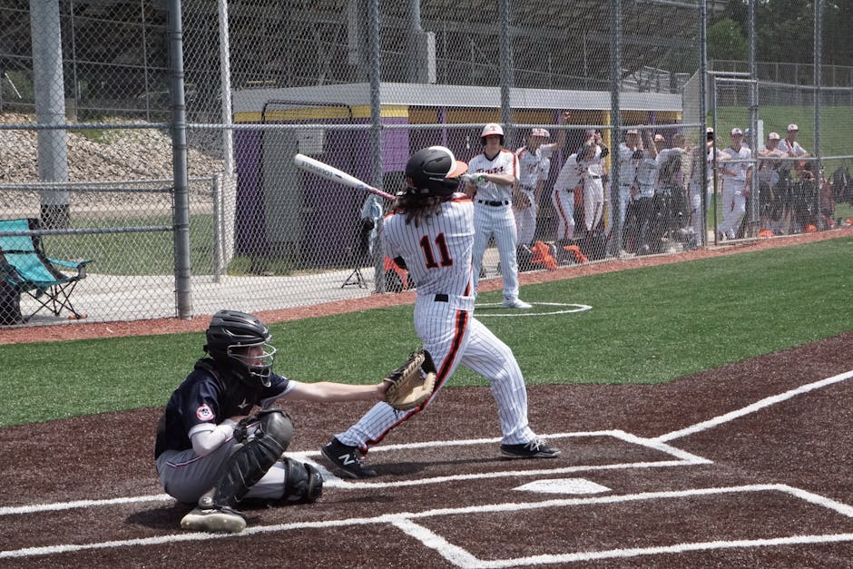 A dynamic scene of a baseball game with a batter swinging at the ball while the catcher is ready. Perfect sports shot.