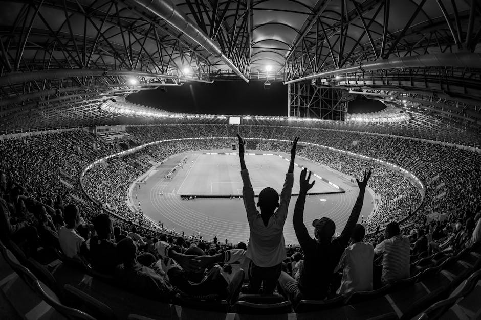 Black and white photo of a lively sports event at Kigali City Stadium, Rwanda.