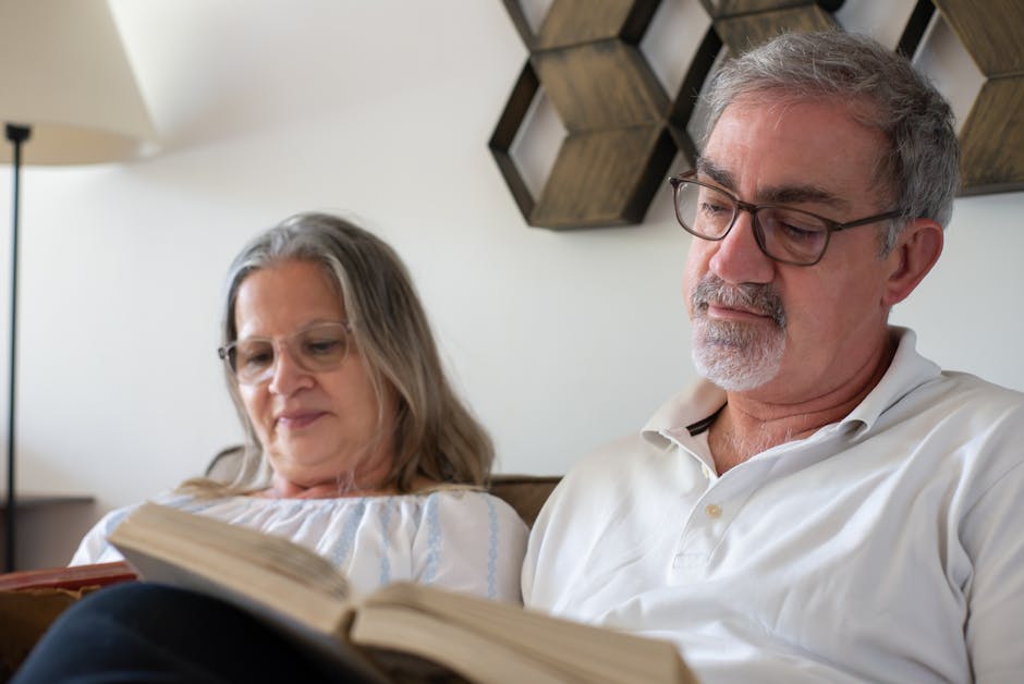 Senior couple enjoying a quiet reading moment at home, showcasing love and companionship.