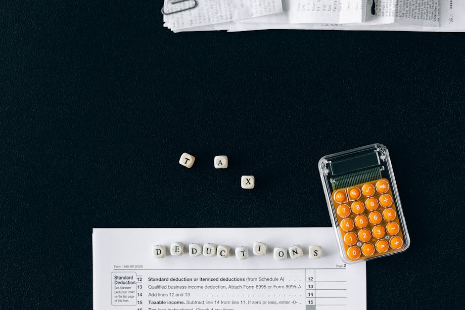 Top-down view of tax deduction items on a black background with a calculator and forms, emphasizing financial planning.