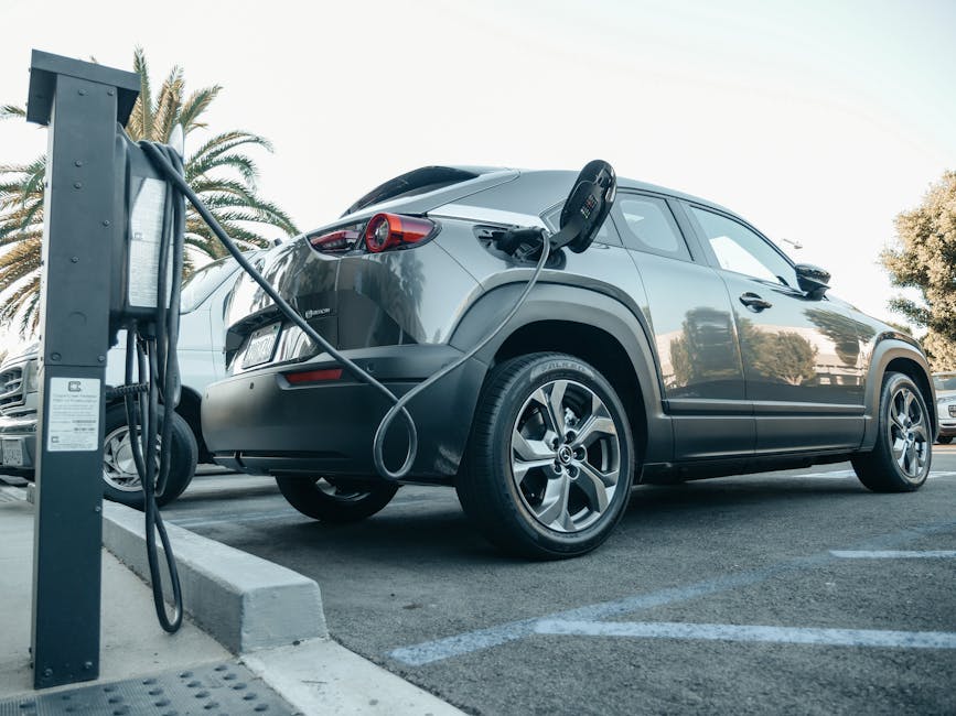 Modern electric vehicle charging at an outdoor station in daylight.