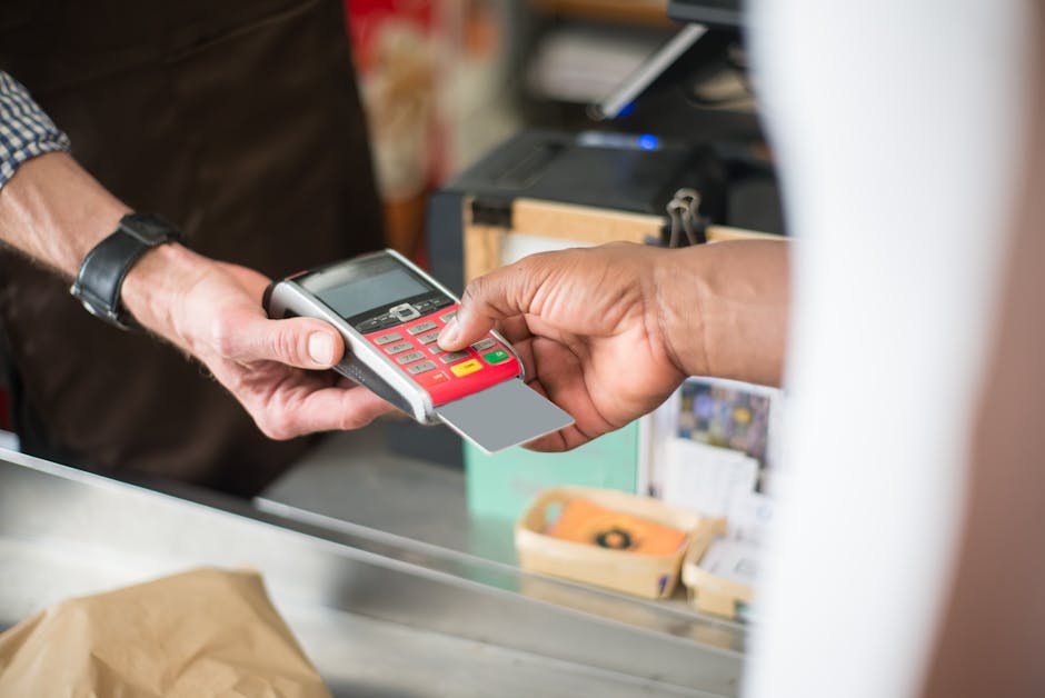A customer uses a card for a contactless payment at a retail store. Business and consumerism concept.