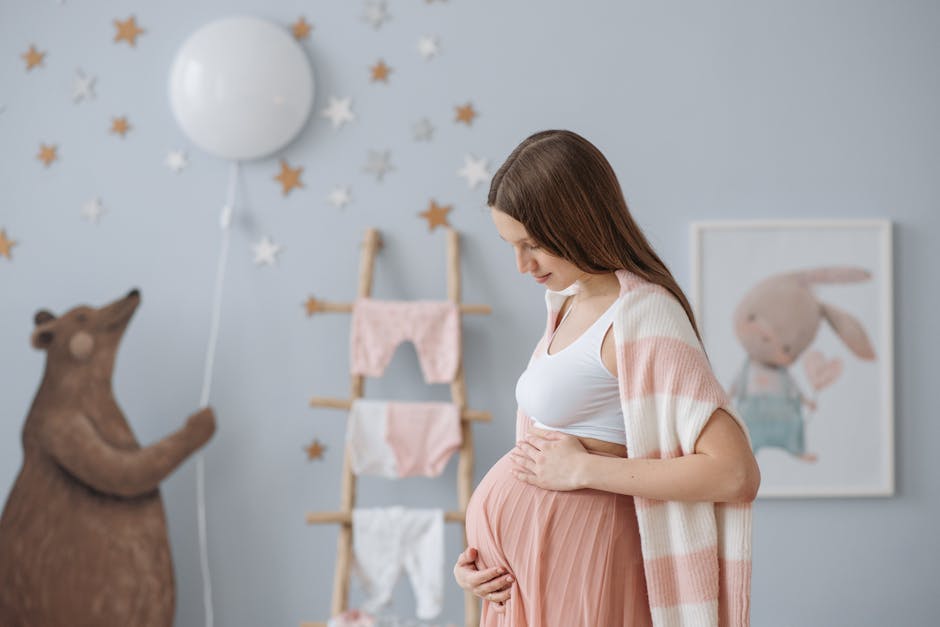 Side view of expectant mother in a cozy nursery with soft pastel decor.