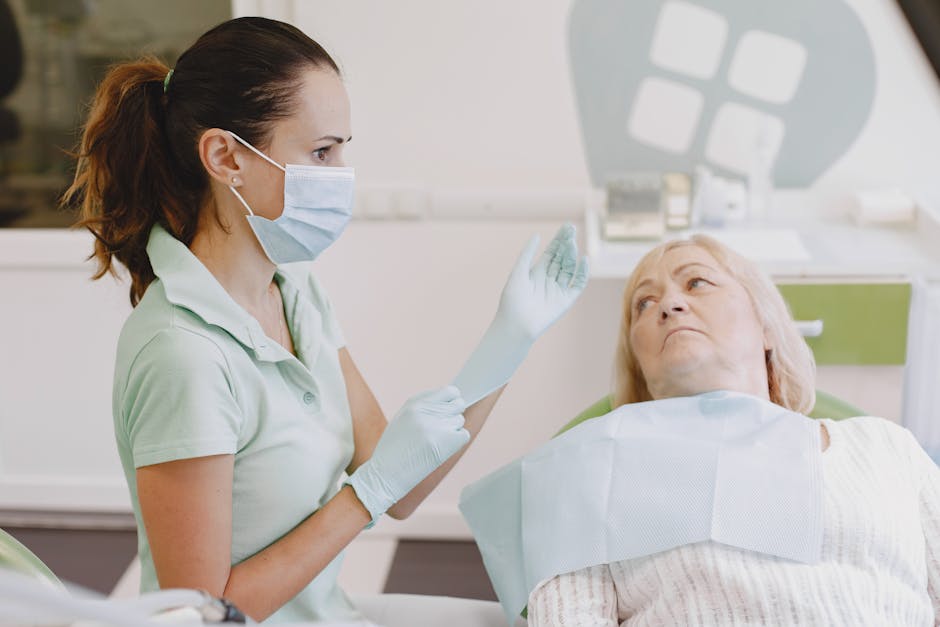 Female dentist prepares for a dental examination with a senior patient in a clinical setting.