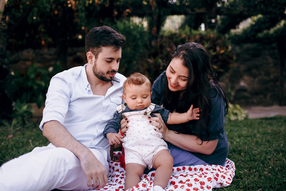 A joyful family of three bonding and playing on a sunny day during a picnic outdoors.