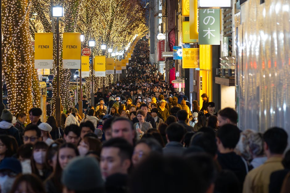 Vibrant crowds in Shibuya under dazzling festive lights during the night in Tokyo, Japan.