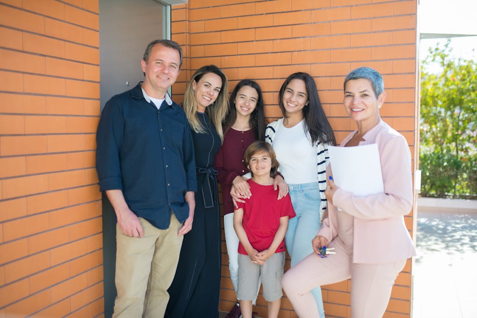 Smiling family with a realtor standing outside their new home, celebrating together.