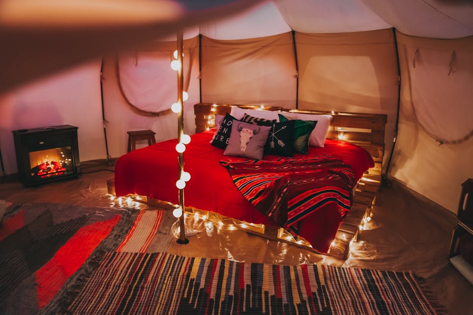 Inviting glamping tent interior with cozy string lights and comfortable bedding for a relaxing retreat.