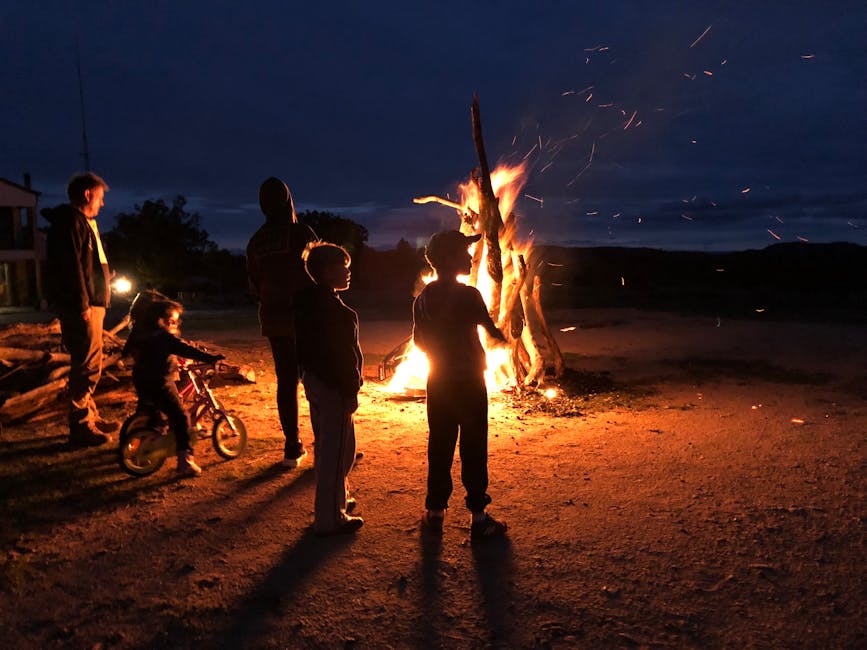 People enjoying a warm bonfire under the night sky in Tingha, Australia.