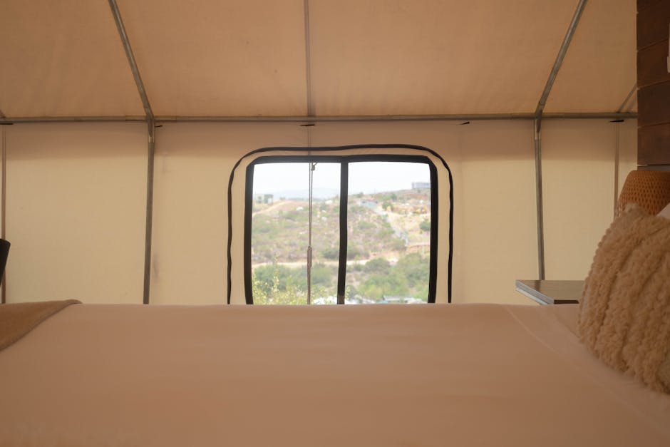 A cozy tent interior with a view of a serene landscape, perfect for a relaxing getaway.