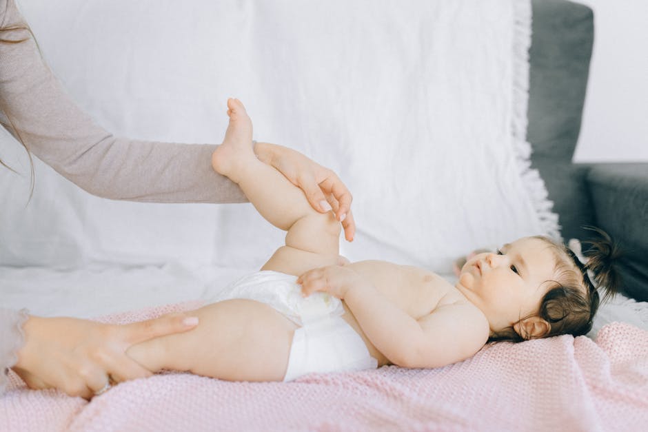 A tender moment with a baby receiving a gentle massage on a bed.