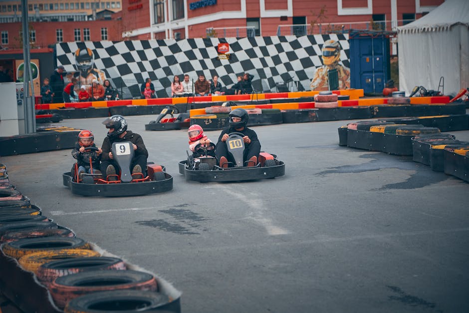 Thrilling outdoor go-kart race with competitors wearing helmets speeding on a track.