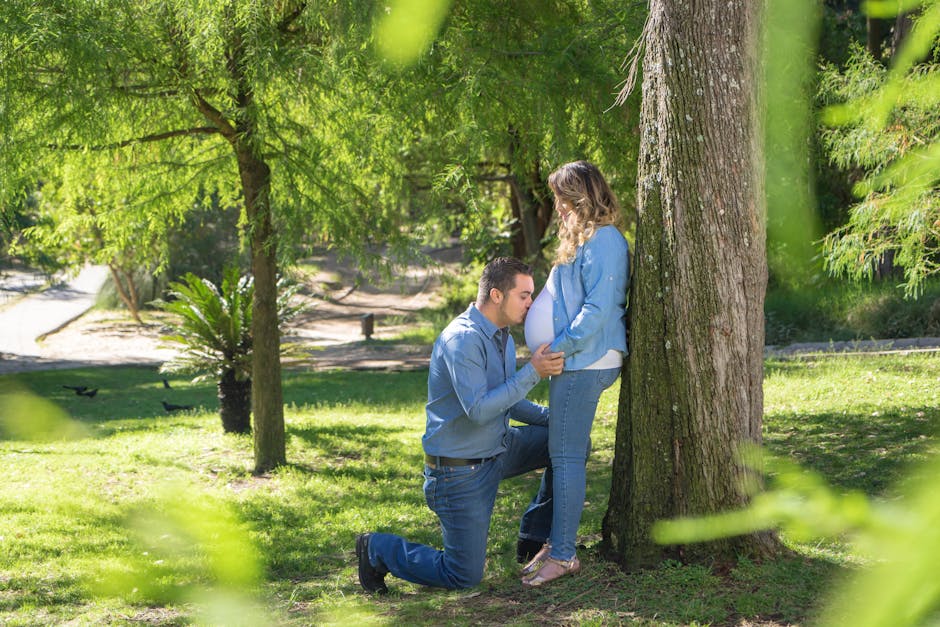 A loving couple in a park embraces the arrival of their baby with joyful anticipation.